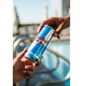 Red Bull can being passed from one hand to another.