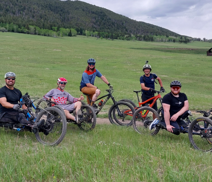 Group of 5 riders together for a bike ride in the foothills on various seated adaptive and two wheel bikes.